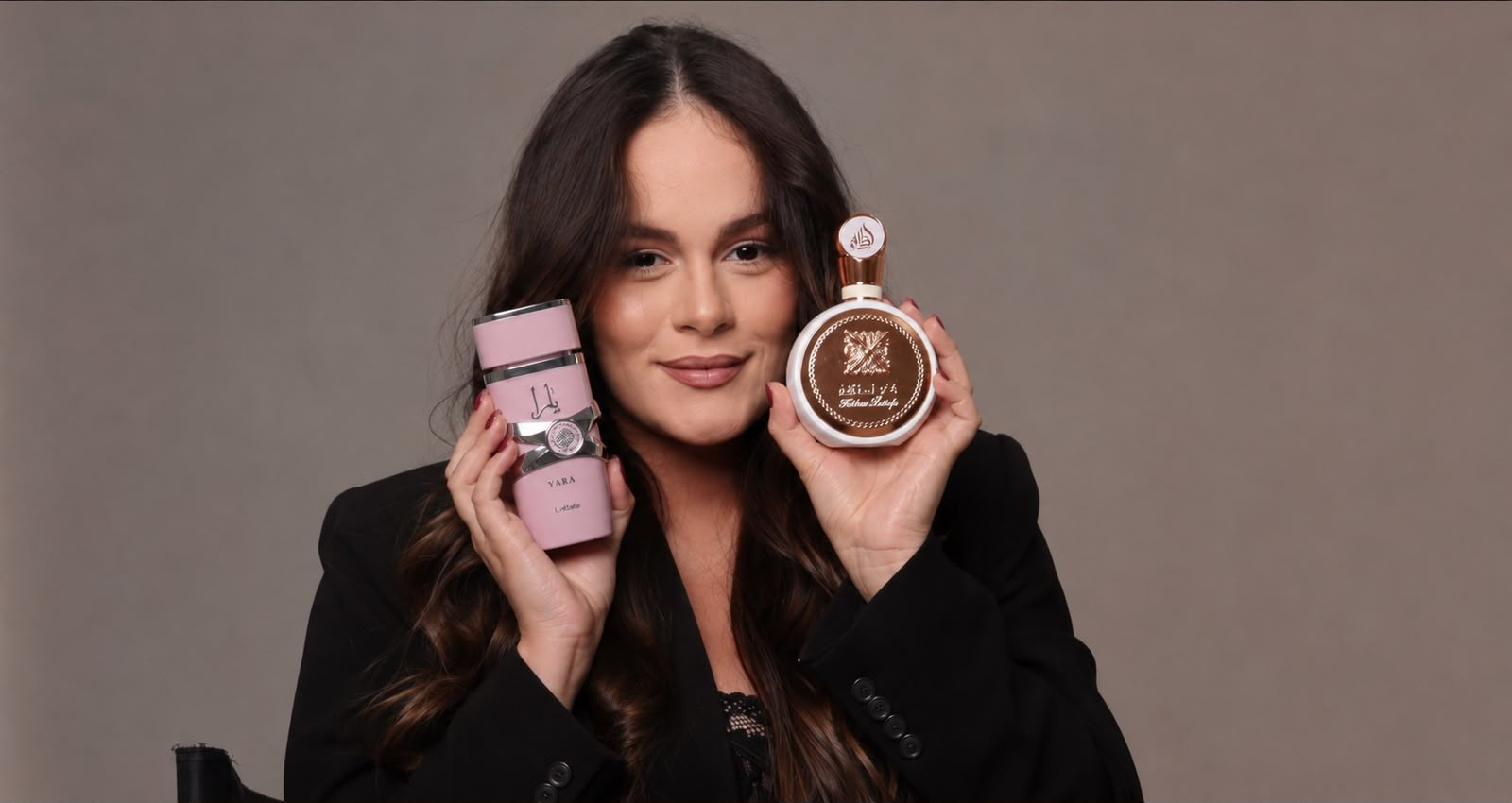 Caroline segurando os perfumes Yara e Fakhar, da Lattafa